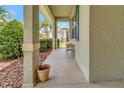 Relaxing covered front porch with textured columns, an American flag, and view of the neighborhood at 3507 Arlington Ridge Blvd, Leesburg, FL 34748