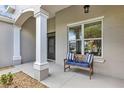 Inviting front porch features a charming bench and decorative columns for a welcoming touch at 3681 Arlington Ridge Blvd, Leesburg, FL 34748