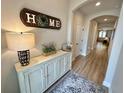 Inviting entryway with a stylish console table, modern lamp, decorative rug, and doorway leading to the living area at 384 Summer Squall Rd, Davenport, FL 33837