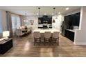 Stylish open-concept kitchen with stainless steel appliances, a large island with bar seating, and an adjacent dining area at 384 Summer Squall Rd, Davenport, FL 33837
