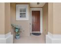 Inviting entryway with a neutral color palette, decorative plant, and a classic front door at 4814 Luge Ln, Orlando, FL 32839