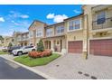 Well-maintained townhome exterior with manicured landscaping, garages, and brick paver driveways, plus street parking at 4814 Luge Ln, Orlando, FL 32839