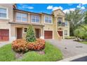Inviting townhome exterior showcasing lush landscaping, garages, and a welcoming facade with multiple windows at 4814 Luge Ln, Orlando, FL 32839