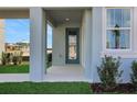 View of a covered entryway with a blue front door and fresh landscaping at 5177 Blanket Flower St, Apopka, FL 32712