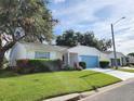 Single-story home featuring a well-kept lawn, shade tree, and a driveway leading to the attached garage at 651 Timbercrest Dr, Leesburg, FL 34748
