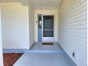 Covered front porch with updated grey flooring and white vinyl siding for a clean, welcoming entryway at 651 Timbercrest Dr, Leesburg, FL 34748