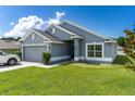 Charming one-story home with a well-kept lawn, a two-car garage, and beautiful landscaping at 7732 Sloewood Dr, Leesburg, FL 34748