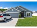 Attractive single-Gathering home featuring a well-manicured lawn, a two-car garage, and a welcoming entrance at 7732 Sloewood Dr, Leesburg, FL 34748