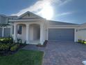 Inviting single-story home with a brick paved driveway, a covered entry and a two-car garage at 2324 Juniper Berry Dr, Minneola, FL 34715