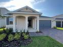 Attractive single-story home with a covered entry, complemented by manicured landscaping at 2324 Juniper Berry Dr, Minneola, FL 34715