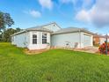 Well-maintained home with light blue exterior, neat landscaping, and an attached two-car garage at 5317 Butterfly Ct, Leesburg, FL 34748