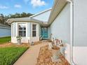 Inviting front entrance featuring a decorative blue door, bay window, and meticulously landscaped walkway at 5317 Butterfly Ct, Leesburg, FL 34748