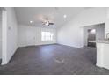 Bright living room with new gray floors, white walls and ceiling fan at 700 Fisher Rd, Ocklawaha, FL 32179