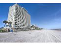 Exterior view of the building from the beach showing multiple units with balconies overlooking the ocean at 89 S Atlantic Ave # 204, Ormond Beach, FL 32176