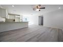 Open-concept living area features wood-look flooring, modern lighting, and a breakfast bar overlooking the kitchen at 8873 Sw 139Th Place Rd, Ocala, FL 34473
