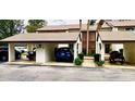 Exterior shot of condo featuring covered parking, manicured shrubs, and neutral paint scheme at 1 Tomoka Oaks Blvd # 102, Ormond Beach, FL 32174