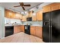 Bright kitchen with wood cabinets, black appliances, and tile floor at 1 Tomoka Oaks Blvd # 102, Ormond Beach, FL 32174