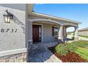 Inviting front porch with brick pavers and a charming red door at 8731 Sw 76Th Street Rd, Ocala, FL 34481