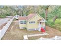 Yellow house with red steps and a white picket fence at 2605 W Silver Springs Blvd, Ocala, FL 34475