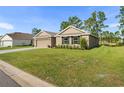 Two-car garage and front yard with landscaping at 141 Hickory Course Cir, Ocala, FL 34472