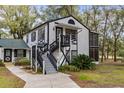 Two-story home with gray stairs and a walkway leading to the entrance at 7874 Midway Drive Ter # V201, Ocala, FL 34472