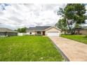 Attractive single-Gathering home with a well-kept lawn and concrete driveway leading to a 2-car garage at 741 Ne 130Th Ter, Silver Springs, FL 34488