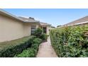 Well-manicured hedges line the walkway of this home, providing privacy and adding to its charm at 9481 Sw 93Rd Loop, Ocala, FL 34481