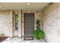 Inviting front entryway featuring a decorative door, brick accents, and lush potted plants at 906 Crestview Dr, Auburndale, FL 33823