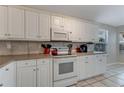 Well-maintained kitchen featuring white cabinetry, tiled countertops, and modern appliances at 915 Ashmeade Ct, Port Orange, FL 32127