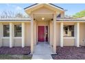 Home's covered front entryway showcasing a red door and decorative rock landscaping at 5238 Ne 1St Ave, Ocala, FL 34479