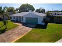 Single-story home with a well-kept front yard, long driveway, blue garage door, and welcoming entrance at 8400 Mattituck Cir, Orlando, FL 32829