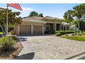 Charming single-story home featuring a paver driveway, tile roof, manicured landscaping, and a two-car garage at 6656 Sw 179Th Court Rd, Dunnellon, FL 34432