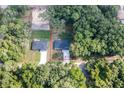 Aerial view displays the home nestled between verdant trees, showcasing the property lines with adjacent homes at 18 Malauka Loop Pass, Ocklawaha, FL 32179