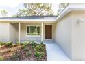 Inviting front porch with a modern door and neatly landscaped flower bed at 61 Fisher Way Crse, Ocklawaha, FL 32179