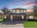 Charming two-story home with a three car garage and a brick paver driveway at 3447 Cypress Grove Dr, Eustis, FL 32736