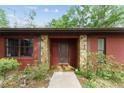 Inviting front entrance adorned with stone accents and lush greenery, creating a warm and welcoming curb appeal at 3149 Sw 200Th Ave, Dunnellon, FL 34431