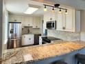 Bright kitchen features granite counters, stainless steel appliances, tile backsplash, and modern lighting at 3370 Ocean Shore Blvd # 5020, Ormond Beach, FL 32176