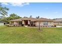 Charming single-story home with a manicured lawn, tasteful landscaping and a vibrant red front door at 10458 Sw 52Nd Ct, Ocala, FL 34476