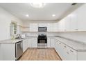 Bright kitchen with white cabinetry, stainless steel appliances, and wood-look flooring at 18341 Nw 142Nd Court Rd, Williston, FL 32696