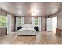 Spacious bedroom with two large windows, wood floors, and a neutral color palette at 18341 Nw 142Nd Court Rd, Williston, FL 32696