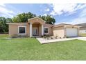 Inviting home featuring a covered front entrance, manicured lawn, and classic architectural details at 2648 Ne 24Th Pl, Ocala, FL 34470