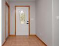 The front entry features tiled flooring, a decorative oval-glass front door with wood trim, and gray painted walls at 3005 Se 156Th Place Rd, Summerfield, FL 34491