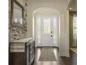 Inviting foyer with a decorative stone wall, dark wood floors, and a stylish front door with sidelights at 1157 Hollow Pine Dr, Oviedo, FL 32765