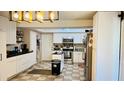 Bright kitchen featuring white cabinets, stainless appliances, tile flooring, and modern lighting at 251 Celery Cir, Oviedo, FL 32765