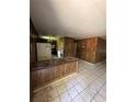Open kitchen area with retro-style bar, tile flooring, wood paneling and appliances at 15750 Ne 150Th Ter, Fort Mc Coy, FL 32134
