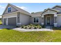 Charming home featuring a gray exterior, manicured landscaping, with a brick paved driveway and walkway to the front door at 17781 Sw 72Nd Street Rd, Dunnellon, FL 34432