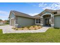 Charming exterior of a single-story home with stone accents and a paved walkway at 17887 Sw 72Nd Street Rd, Dunnellon, FL 34432