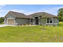 Well-maintained home featuring a lush lawn, a garage, and tasteful landscaping at 17887 Sw 72Nd Street Rd, Dunnellon, FL 34432