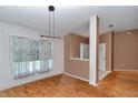 Bright dining area with wood floors, modern lighting, and a view into the living space at 3968 Sw 131St Place Rd, Ocala, FL 34473