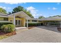 Traditional home boasts a covered front entrance, carport, lush greenery, and inviting curb appeal at 2135 Se 12Th St, Ocala, FL 34471